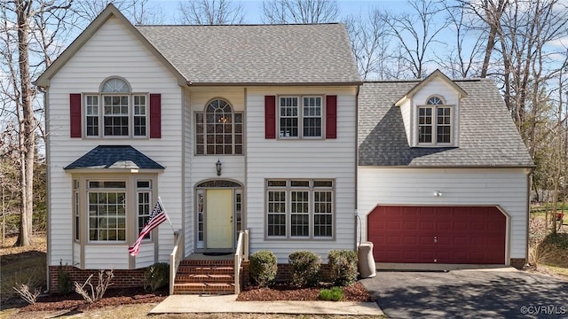 view of front of property with aphalt driveway, a garage, and roof with shingles