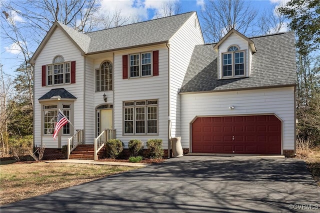 view of front of home featuring an attached garage, a shingled roof, and driveway