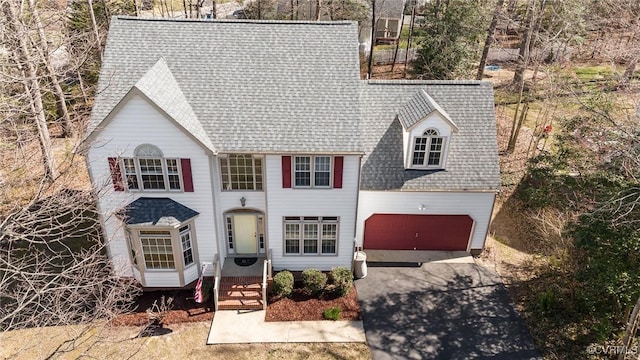 view of front of house featuring entry steps, a garage, driveway, and a shingled roof