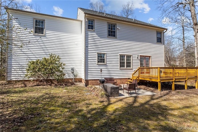 back of property featuring a patio, a yard, and a wooden deck