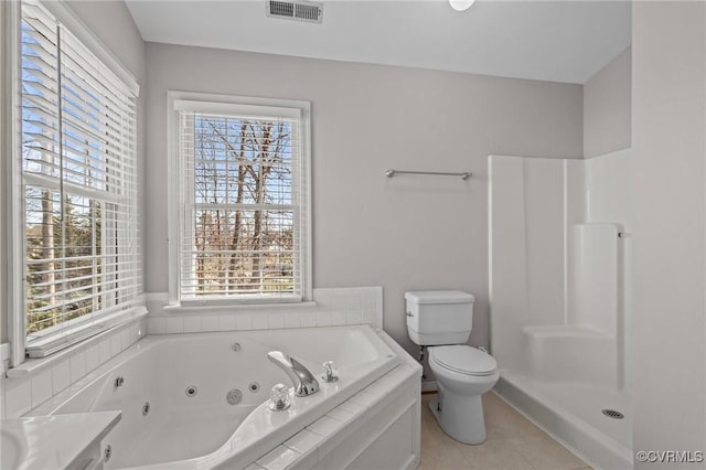 bathroom featuring toilet, a healthy amount of sunlight, visible vents, and a whirlpool tub