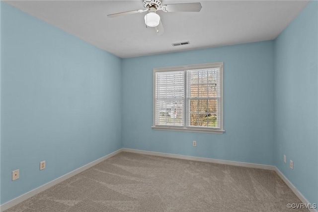 spare room with ceiling fan, carpet, visible vents, and baseboards