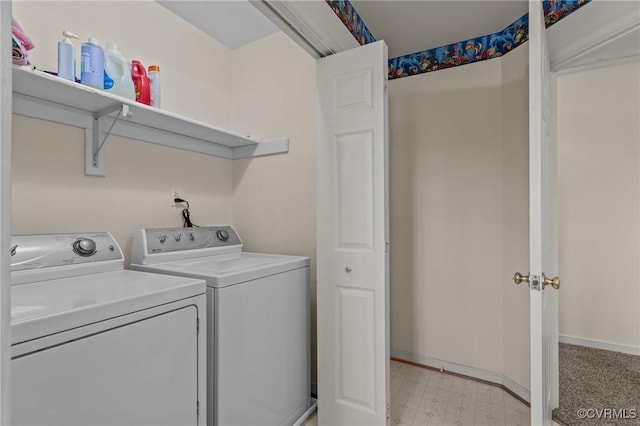 clothes washing area with laundry area, light floors, baseboards, and washing machine and clothes dryer