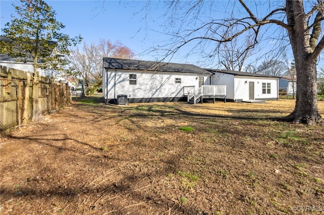 rear view of property featuring central air condition unit, a wooden deck, and fence