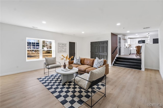 living area featuring stairway, recessed lighting, visible vents, and light wood finished floors