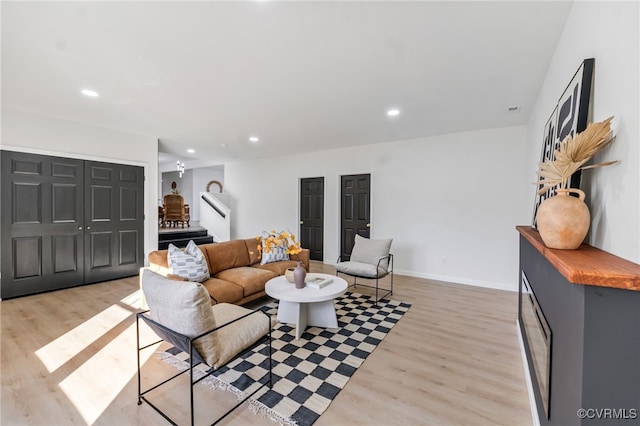 living room with stairway, recessed lighting, baseboards, and light wood finished floors