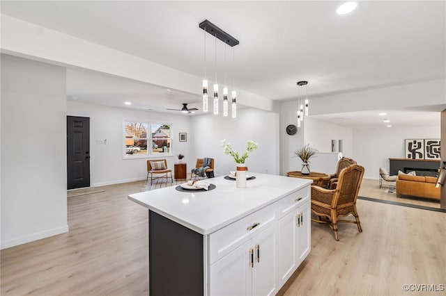 kitchen featuring light wood finished floors, open floor plan, white cabinetry, and a center island