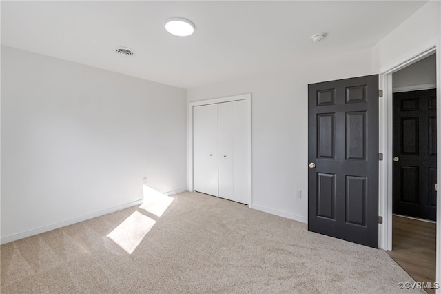 unfurnished bedroom featuring a closet, baseboards, visible vents, and carpet floors