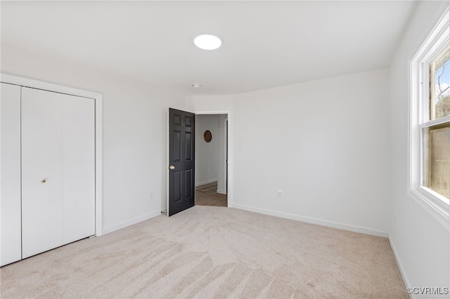 unfurnished bedroom featuring a closet, baseboards, and carpet floors