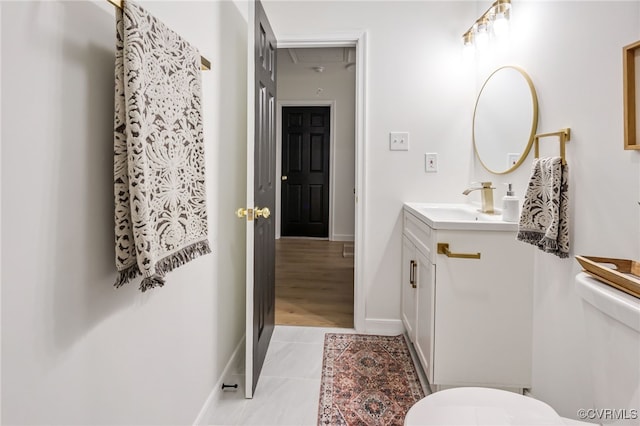 bathroom featuring tile patterned floors, baseboards, toilet, and vanity