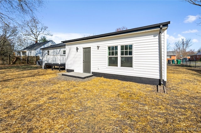 rear view of property featuring a wooden deck and fence