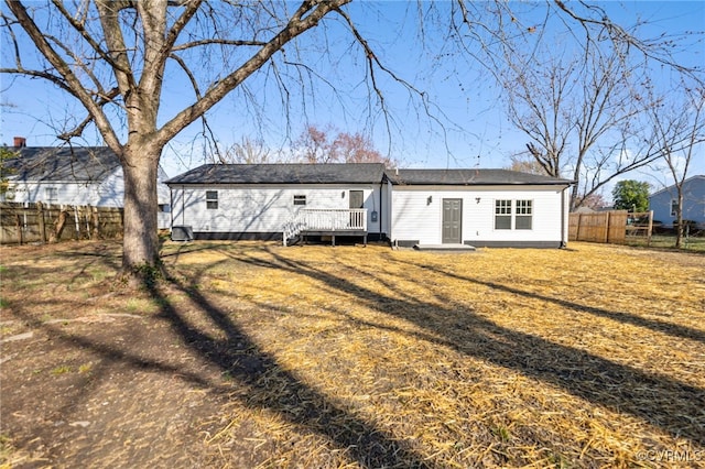 back of house with a lawn, a deck, and fence