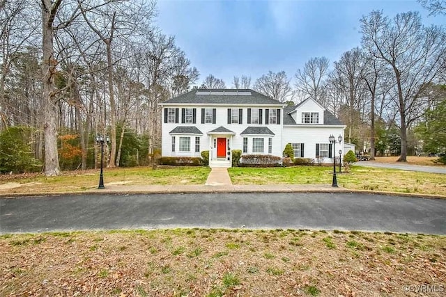 colonial home featuring a front lawn