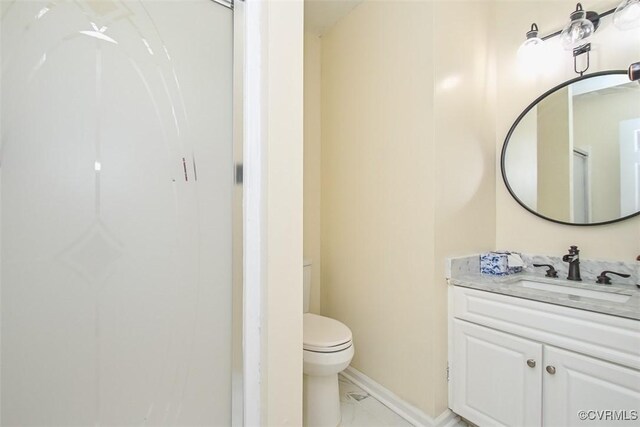 bathroom featuring vanity, baseboards, toilet, and marble finish floor