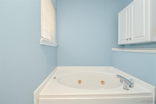 bathroom with a tub with jets