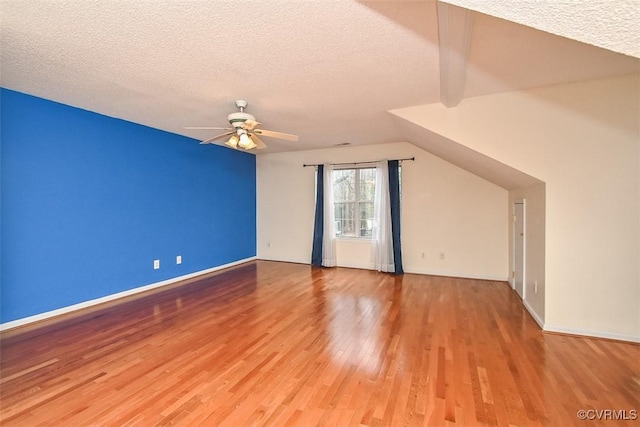 additional living space with baseboards, a textured ceiling, ceiling fan, and wood finished floors