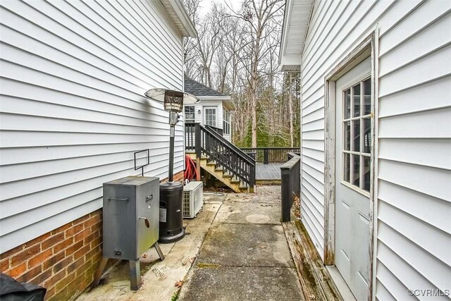 view of property exterior with stairs, ac unit, and a wooden deck