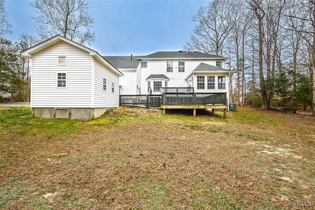 back of house with a lawn, roof with shingles, a wooden deck, and central air condition unit