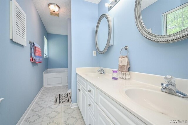 3090 Magnolia Woods Ct, Quinton, VA 23141 - bathroom with baseboards, a sink, a textured ceiling, and double vanity