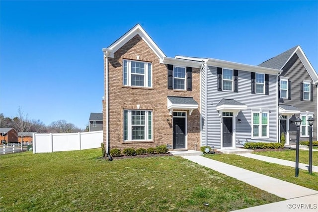 townhome / multi-family property featuring brick siding, a front yard, and fence