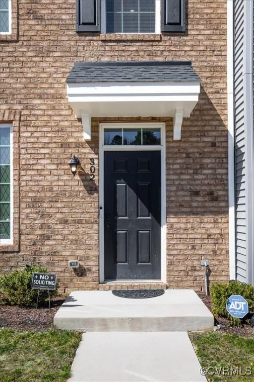 doorway to property featuring brick siding