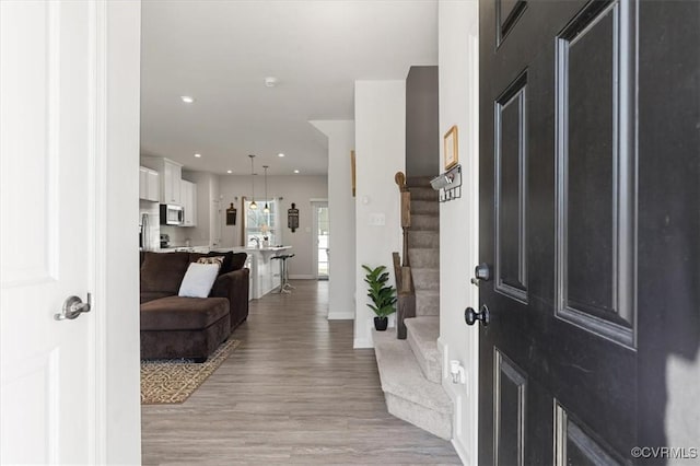 entryway featuring stairway, recessed lighting, baseboards, and light wood-style floors