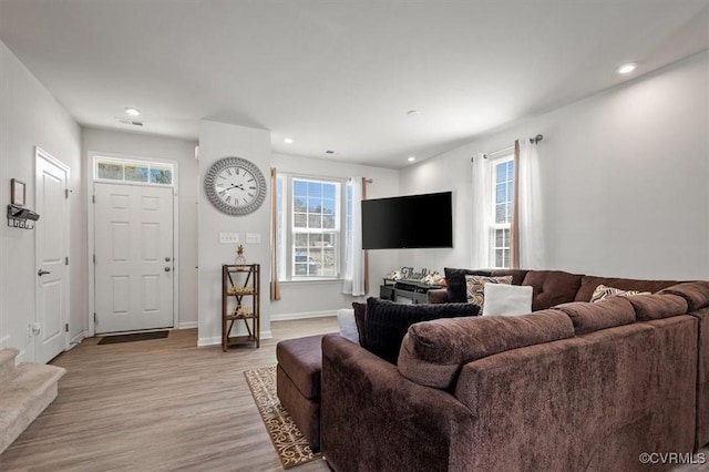 living area with a wealth of natural light, recessed lighting, light wood-style flooring, and baseboards