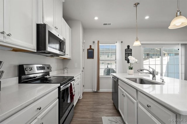 kitchen featuring visible vents, a sink, stainless steel appliances, white cabinets, and light countertops