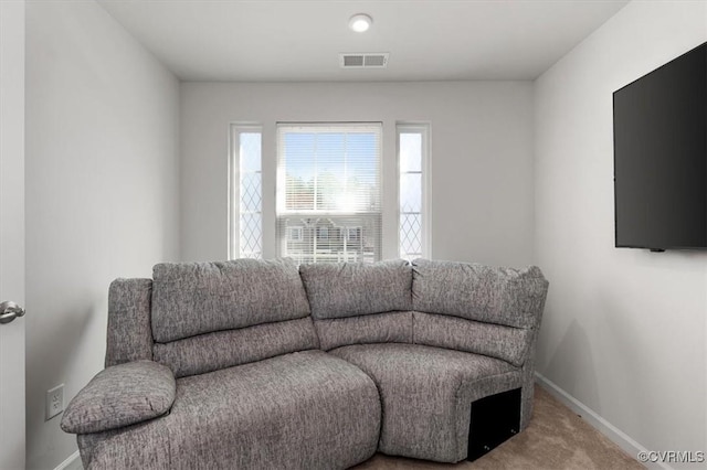 carpeted living area featuring visible vents and baseboards