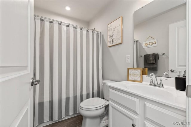 bathroom with vanity, toilet, and wood finished floors