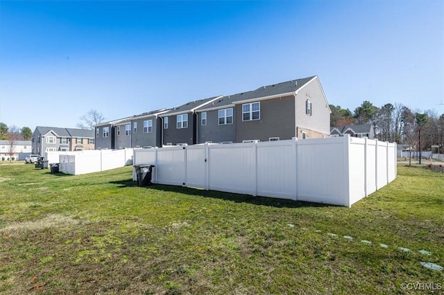 rear view of house with a residential view, a lawn, and fence