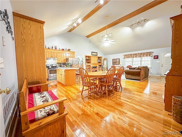 dining area with track lighting, lofted ceiling with beams, light wood-style floors, and a ceiling fan