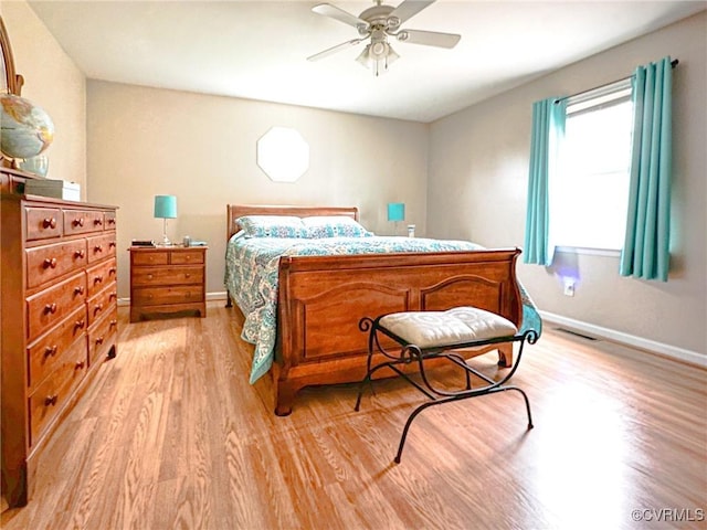 bedroom with light wood finished floors, a ceiling fan, and baseboards