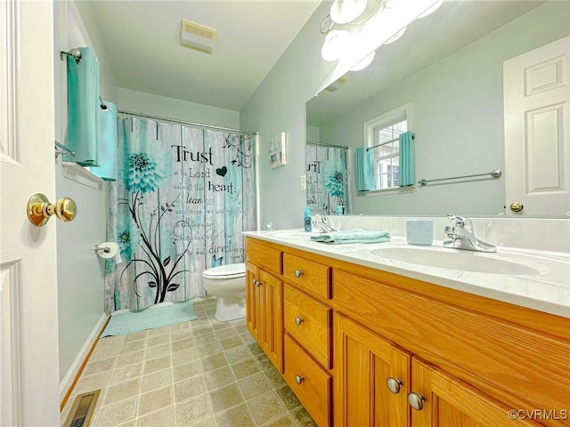 bathroom featuring double vanity, visible vents, toilet, and a sink