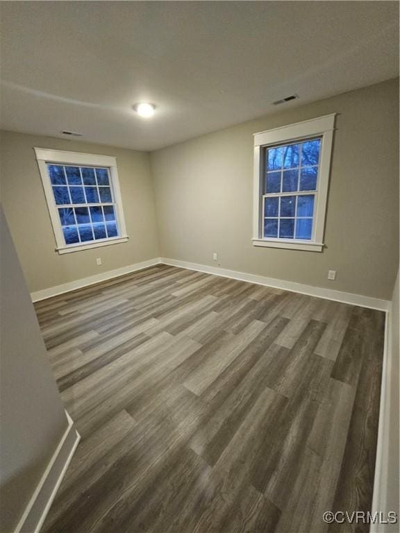 empty room with baseboards and wood finished floors