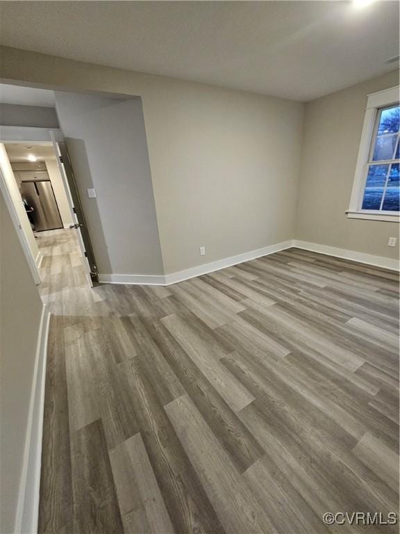 unfurnished room with baseboards and wood finished floors