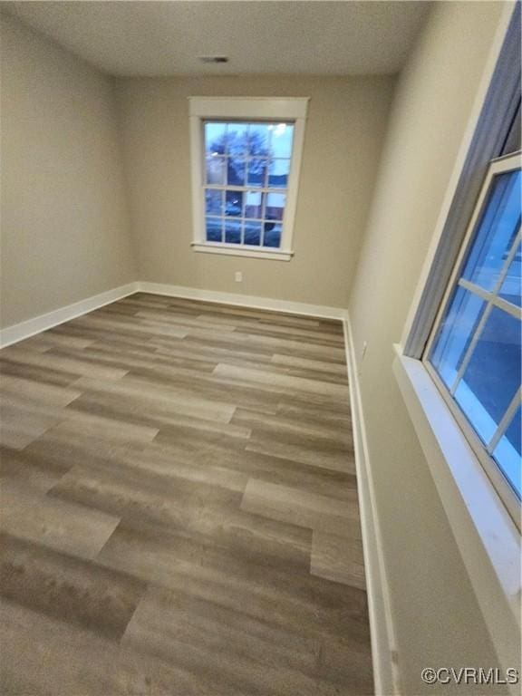 spare room featuring wood finished floors and baseboards