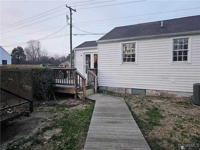 rear view of property with a wooden deck and a shingled roof