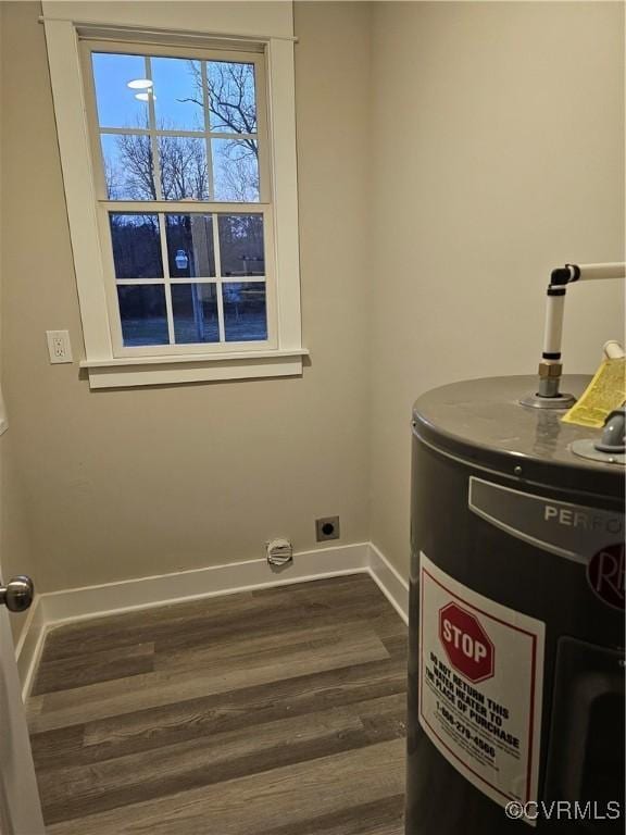 laundry room with dark wood finished floors, baseboards, and water heater