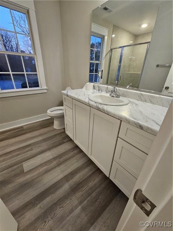 full bathroom featuring vanity, wood finished floors, visible vents, and a stall shower