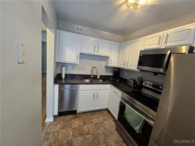 kitchen featuring a sink, white cabinets, visible vents, and stainless steel appliances