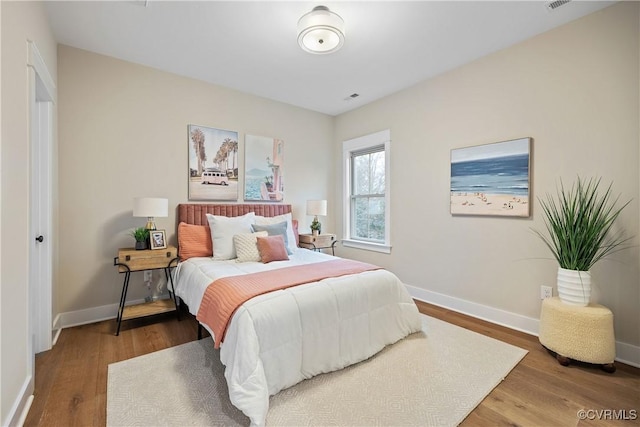 bedroom with baseboards and wood finished floors