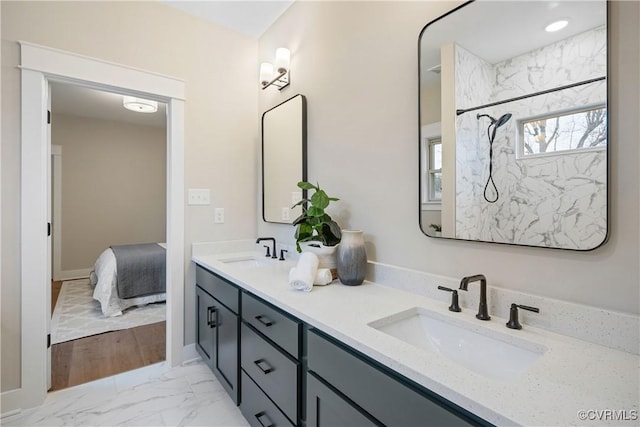 full bathroom featuring double vanity, marble finish floor, and a sink