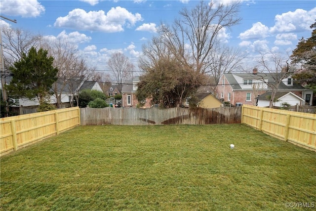 view of yard featuring a fenced backyard and a residential view