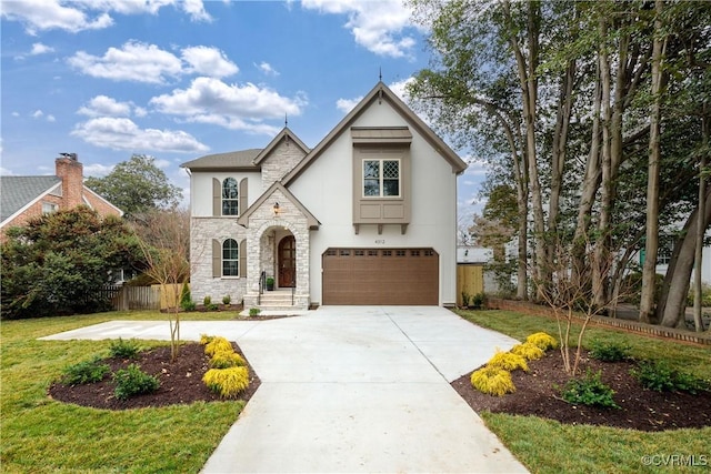 view of front facade with fence, driveway, stucco siding, a garage, and stone siding