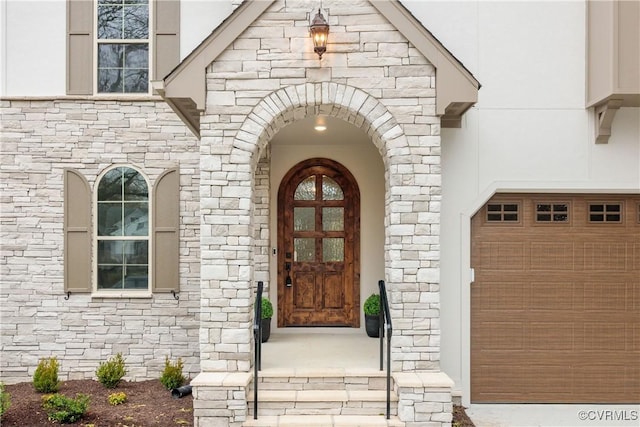 view of exterior entry with stone siding and stucco siding