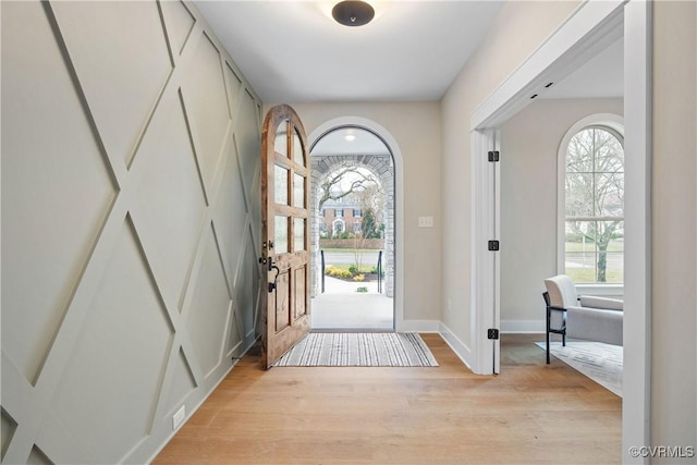 entryway with baseboards and light wood-style flooring