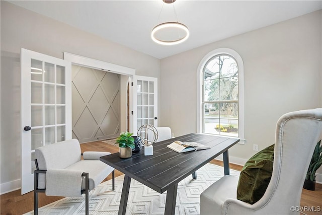 office space featuring wood finished floors, baseboards, and french doors