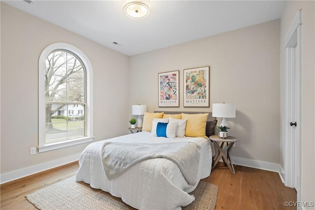 bedroom with baseboards and wood finished floors