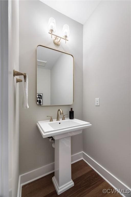 bathroom featuring a sink, baseboards, and wood finished floors